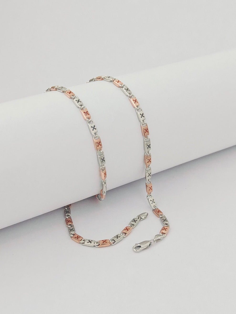 Silver chain  on a light gray surface