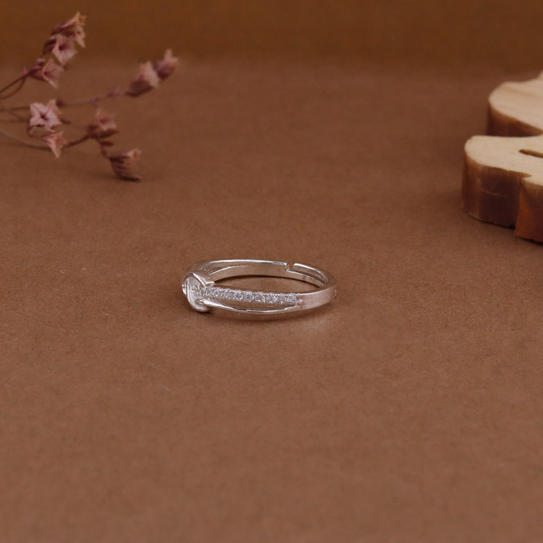 Silver ring on a brown surface with dried flowers and wood slice by kivara