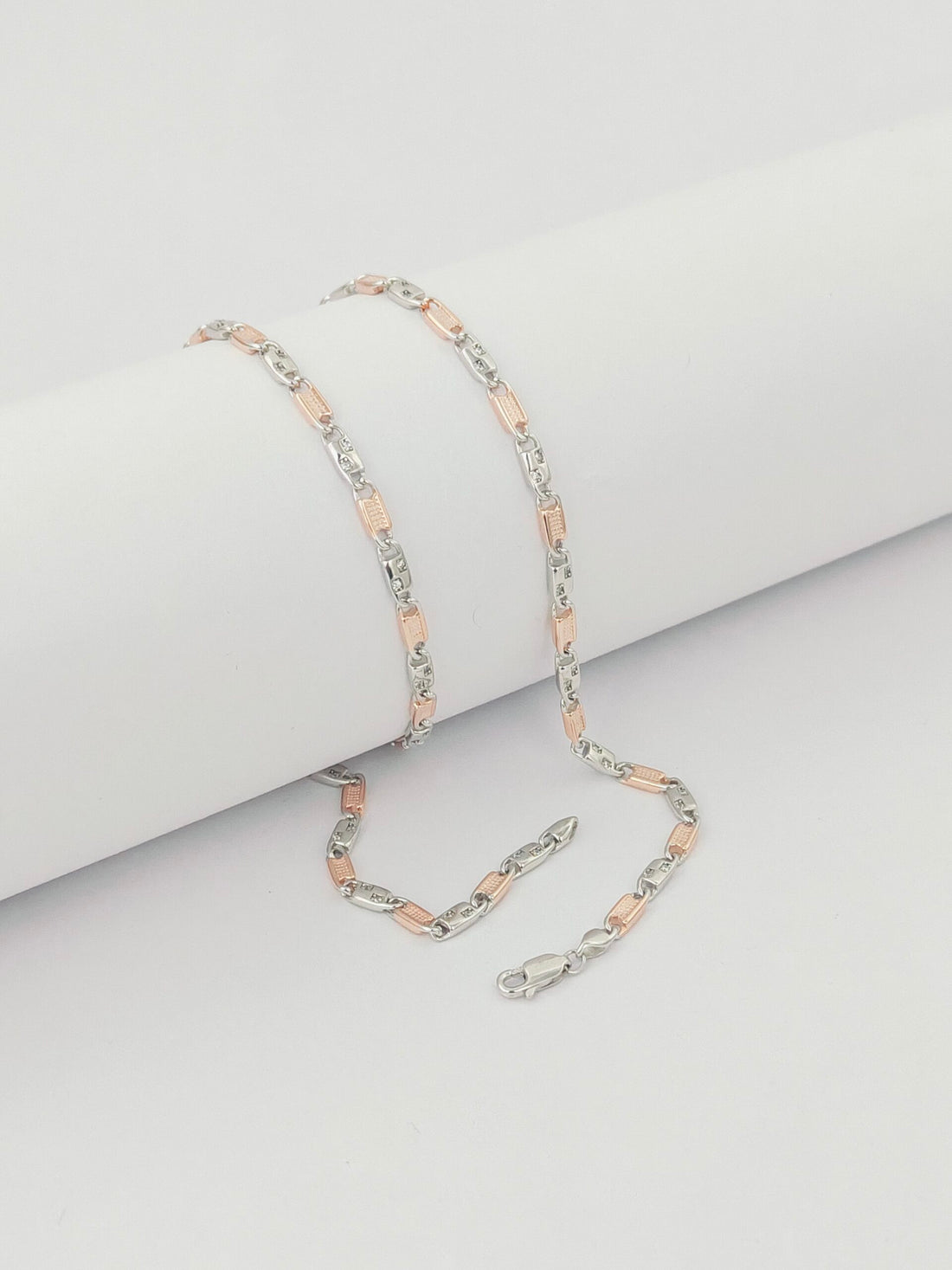 Two silver and rose gold chain  on a light gray background by kivara jewels