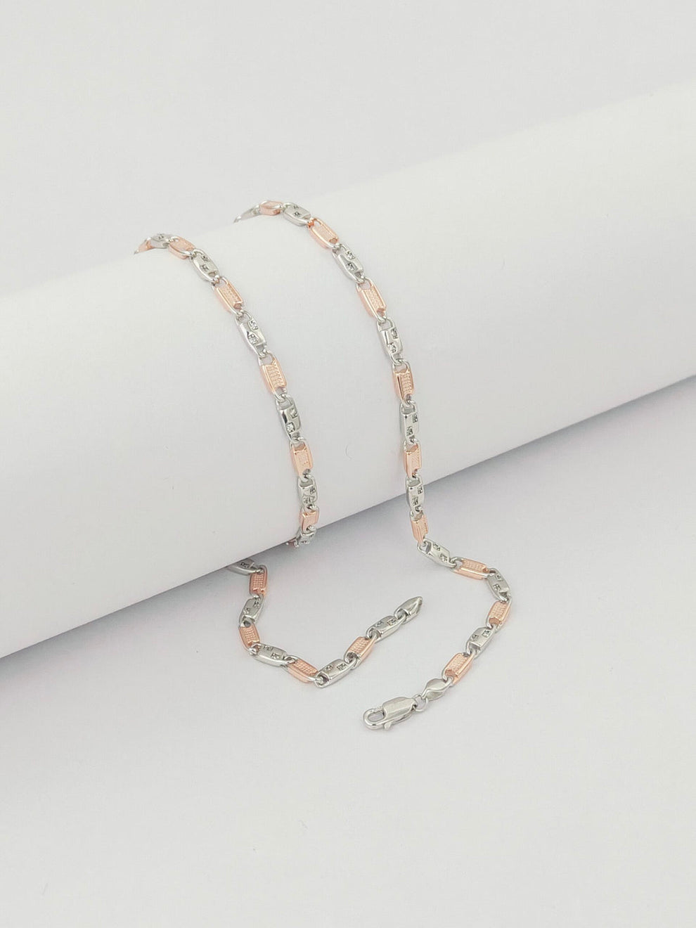 Two silver and rose gold chain  on a light gray background by kivara jewels