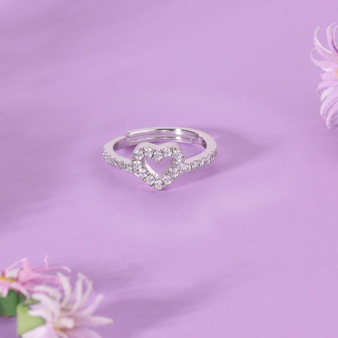 Silver heart-shaped ring on a purple background with flowers