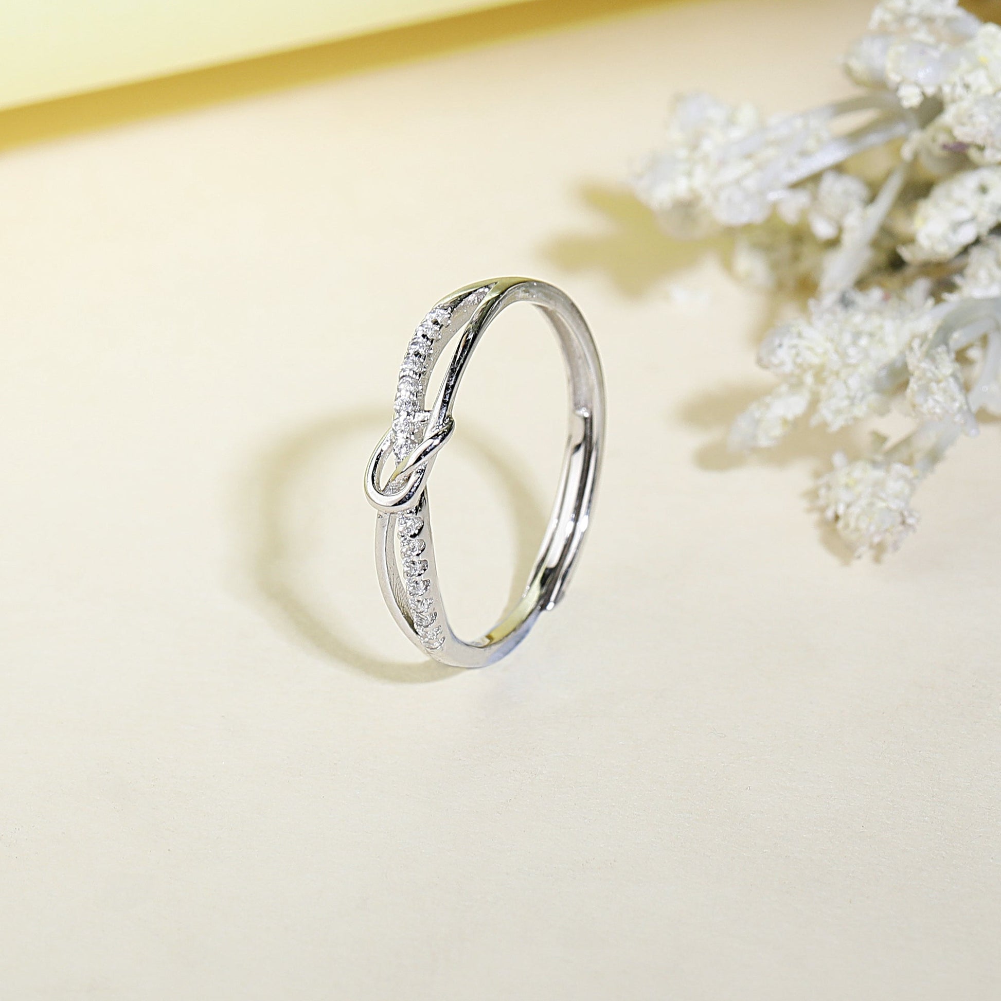 Silver ring with diamond accents on a light background