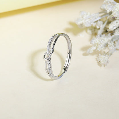 Silver ring with diamond accents on a light background