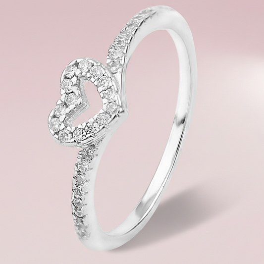 Silver ring with heart-shaped design and embedded diamonds on a pink background