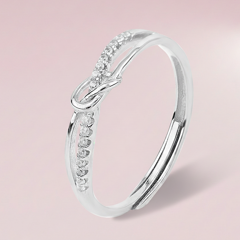 Silver ring with small diamonds on a light pink background