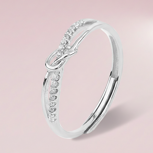 Silver ring with small diamonds on a light pink background