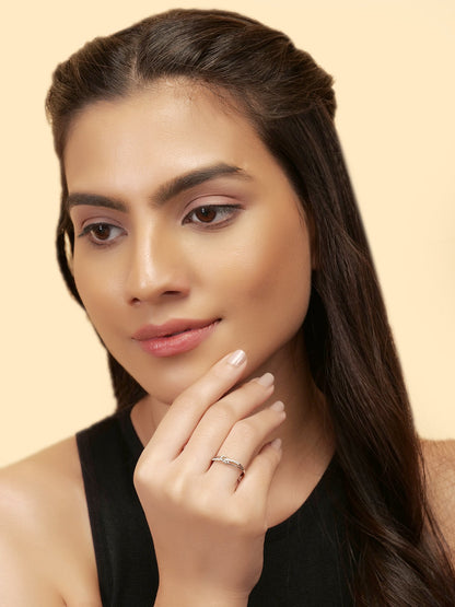 Woman with long dark hair wearing a black top against a beige background