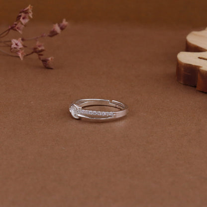 Silver ring on a brown surface with dried flowers and wood slice by kivara