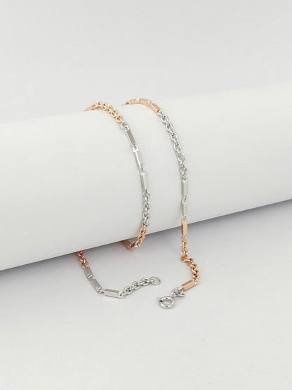 Two gold bracelets on a light gray surface