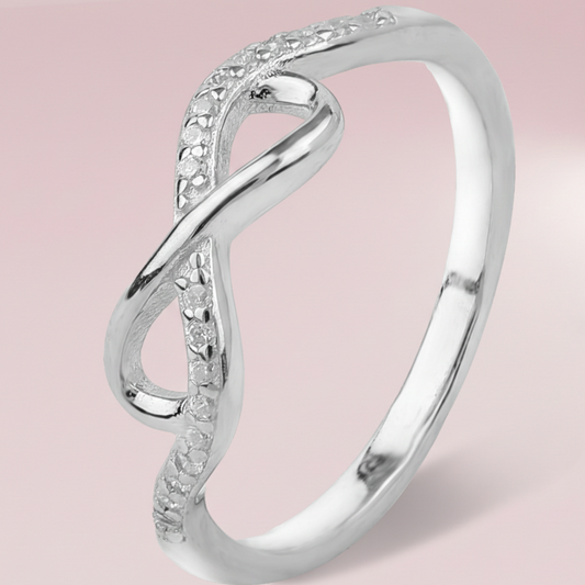 Silver ring with diamond accents on a pink background